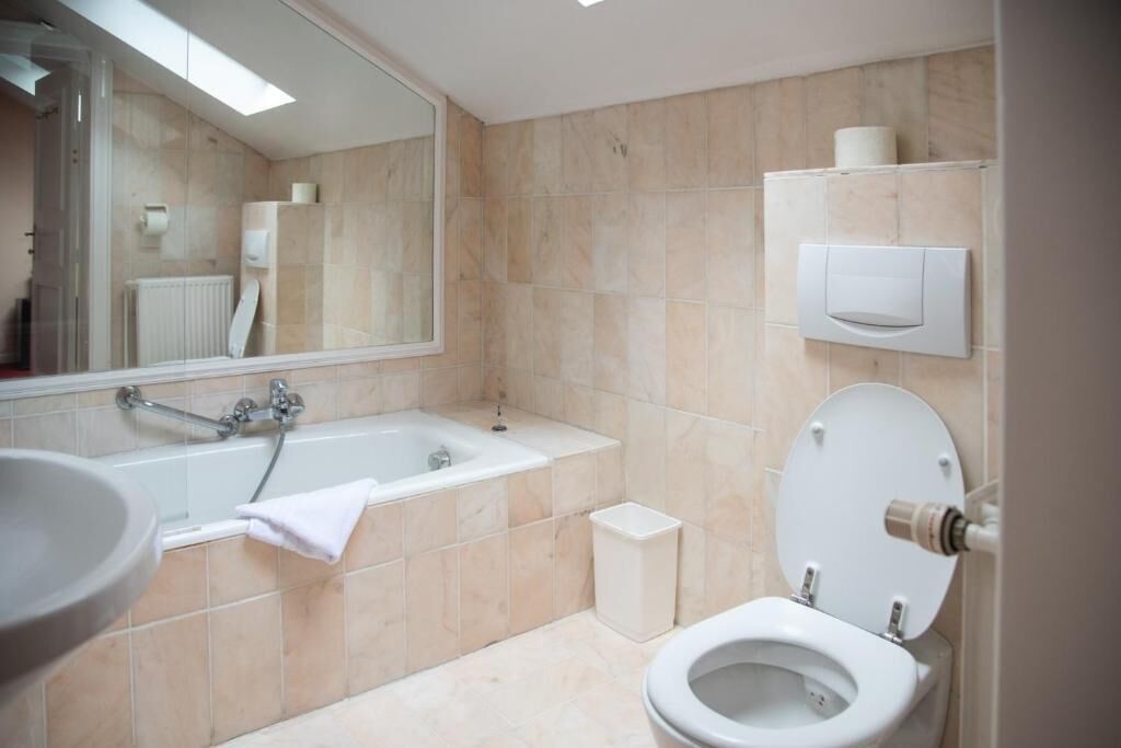 A modern bathroom with a bathtub, toilet, and sink.