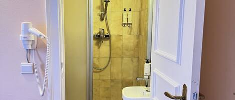 Un baño de hotel con ducha, lavabo e inodoro.