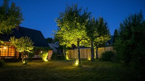 A backyard with trees and a wooden fence. - Zotlar House (Bohinj)