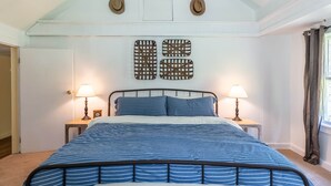 A bedroom with a bed, two nightstands, two lamps, a window with curtains, and a wall with two decorative items. - Dragonfly Cottage-Pet-friendly, relaxing Wellsboro retreat (Charleston Township)