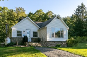 A two-story house with a stone foundation, a chimney, and a number '117' on the front door. - Dragonfly Cottage-Pet-friendly, relaxing Wellsboro retreat (Charleston Township)