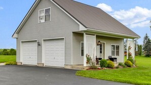 A single-story house with a garage, a covered porch, and a well-maintained lawn.