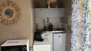 A compact kitchenette with a microwave, coffee maker, and a small refrigerator. - Studio 20m2 30 minutes from the beach (Saussines)