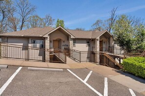 A two-story building with a stone facade, a welcoming sign, and a parking lot. - Spacious remodel 5 mn-SDC, 10 mn-Lake, 2BR 2.5BA (Branson West)