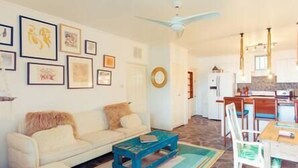 A living room with a sofa, coffee table, and artwork on the wall.