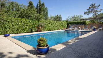 Una piscina al aire libre, tumbonas