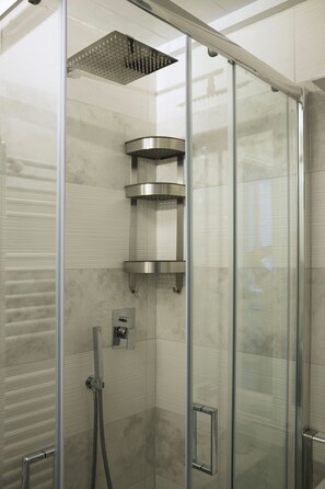 Eine begehbare Glasdusche mit modernem Design, inklusive Regendusche und Bedienfeld.