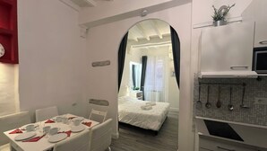 Una habitación de hotel moderna con comedor, cocina y dormitorio.