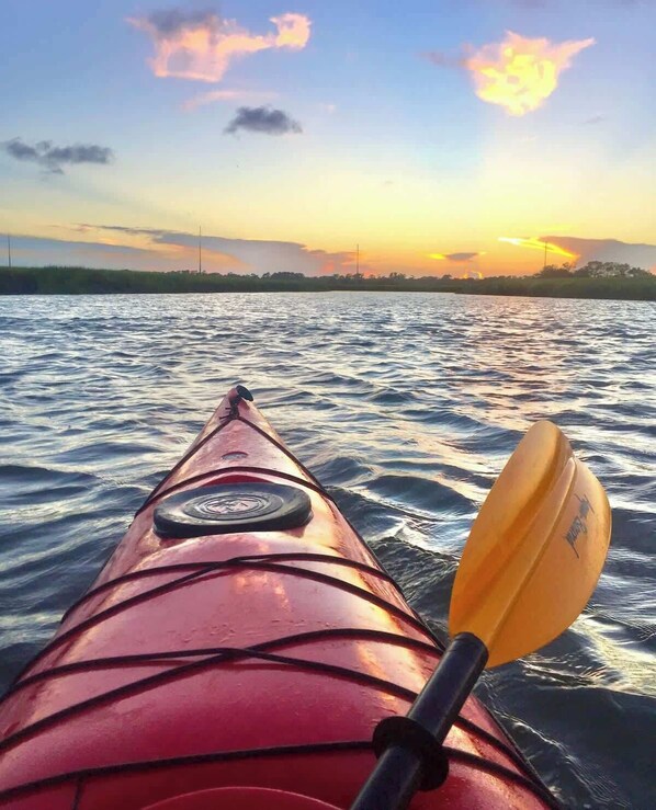 Ein Kajak mit Paddel auf dem Wasser bei Sonnenuntergang.