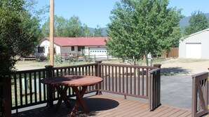 A wooden deck with a table and chairs, surrounded by a wooden fence.