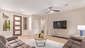 A living room with two sofas, a coffee table, a TV, and a ceiling fan. - 🏝5 Min to TOP Shop + dine, 🐶 OK, 900mbps internet (Gilbert)