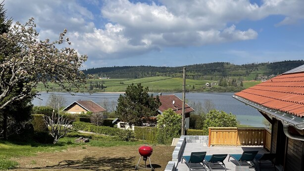 Un espace patio comprenant un jacuzzi, des sièges d’extérieur et un barbecue.