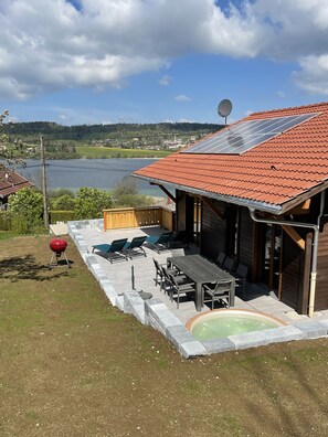 A house with a patio, outdoor furniture, a barbecue grill, and a swimming pool. - CHALET WITH SPA AND LAKE VIEW (Montperreux)