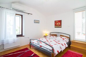 A bedroom with a bed, a window with curtains, a bedside lamp, and a picture on the wall. - Charming Apartment With a Terrace - In the heart of old town (Koper)