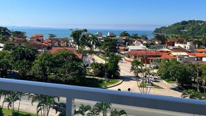 Uma área residencial costeira com casas, palmeiras e vista clara para o oceano.