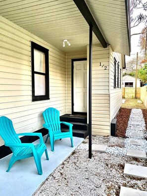A house with a porch, two turquoise chairs, and a number '1/2' on the door. - Adorable unit 5 miles from the beach! (St. Petersburg)