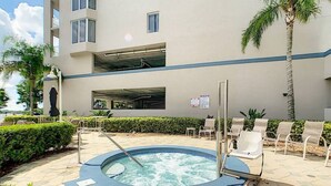 Ein Poolbereich mit Liegestühlen und einem Whirlpool.