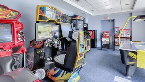 Eine Reihe von Spielautomaten in einem Raum mit grauem Teppich und weißen Wänden.