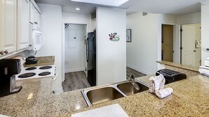 Eine moderne Küche mit weißen Schränken, einem Einbauherd, einem Kühlschrank und einem Toaster.