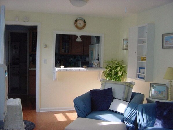 A living room with a blue sofa, a small table, and a potted plant.