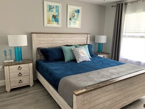 Une chambre à coucher avec un lit en bois, deux tables de chevet avec des lampes et des œuvres d’art accrochées au mur.