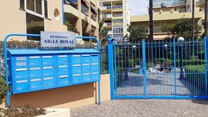Een hekpoort met een blauwe brievenbus en een bord waarop 'Residence Aigle Royal' staat.