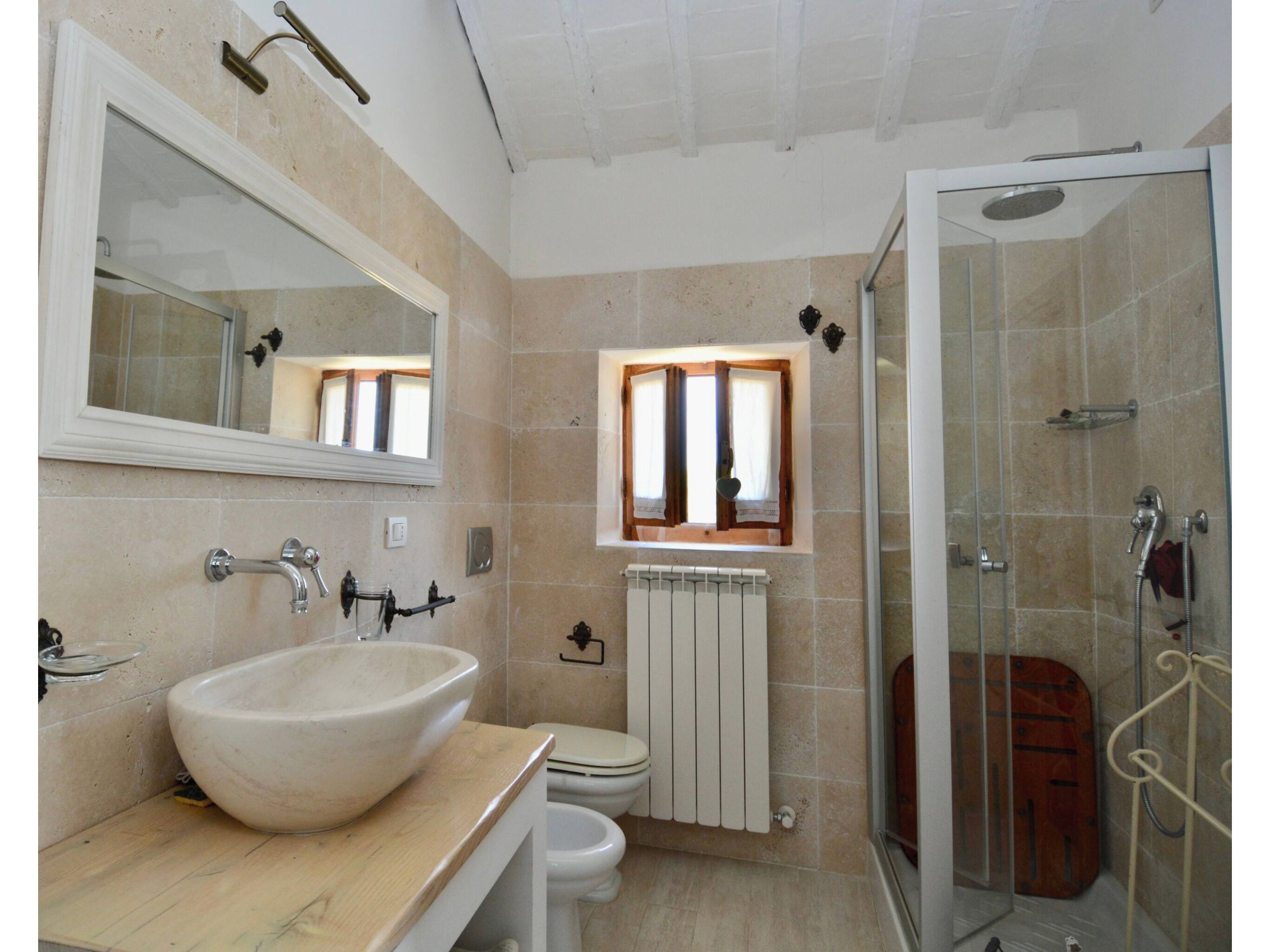 A bathroom with a large sink, toilet, and shower.