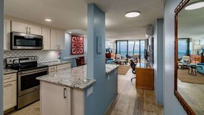 A modern kitchen with a microwave, stove, and granite countertop.