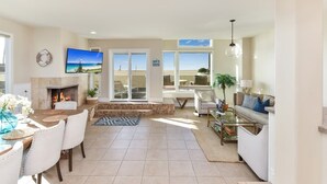 A spacious living area with a fireplace, a television, and a view of the outdoors.