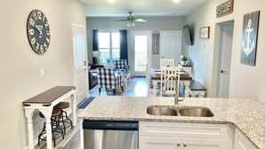 A modern kitchen with white cabinets, a stainless steel dishwasher, and a granite countertop. - NEW! SPACIOUS condo—STUNNING views & CLOSE to Strip, SDC & LAKE! Sleeps 12!! (Branson)