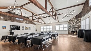 A conference room with long tables, white chairs, and chandeliers. - Club Hotel Colorado (Idaho Springs)