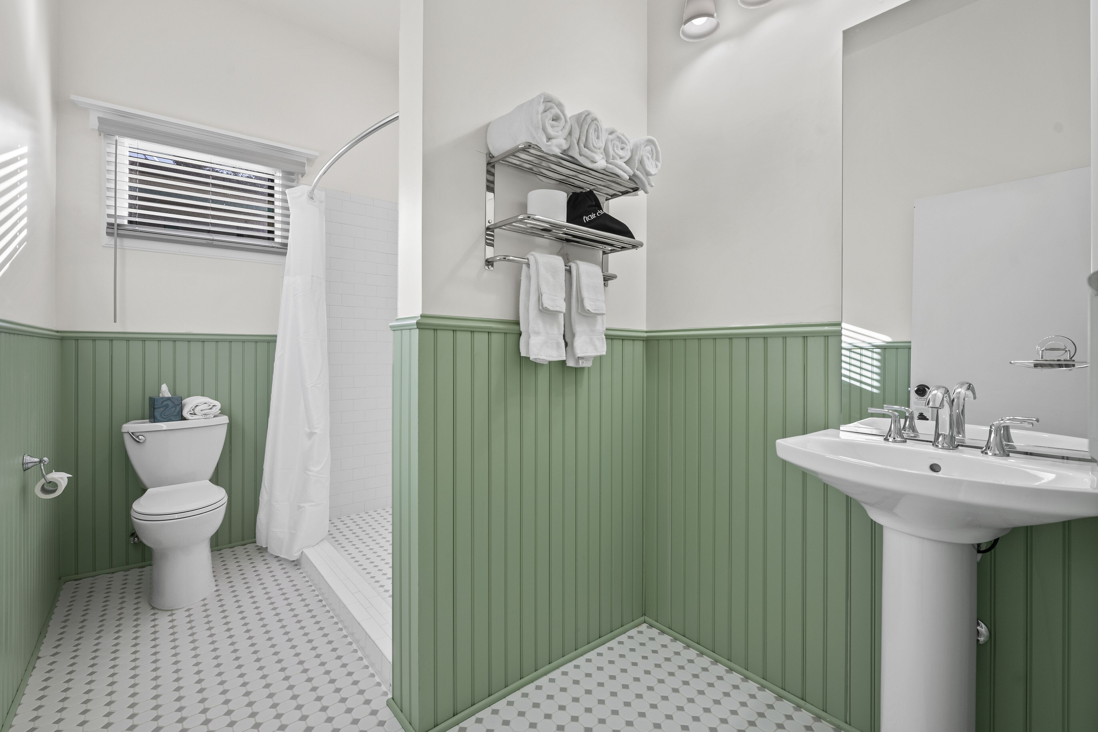 Een badkamer met toilet, wastafel en handdoekhouder.