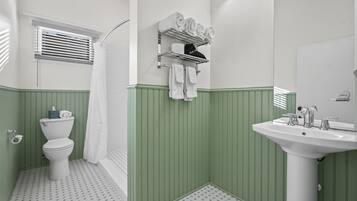Een badkamer met toilet, wastafel en handdoekhouder.