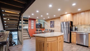 Una cocina moderna con armarios de madera, un refrigerador de acero inoxidable y una isla central.