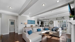 A spacious living room with a sectional sofa, a coffee table, and a fireplace.