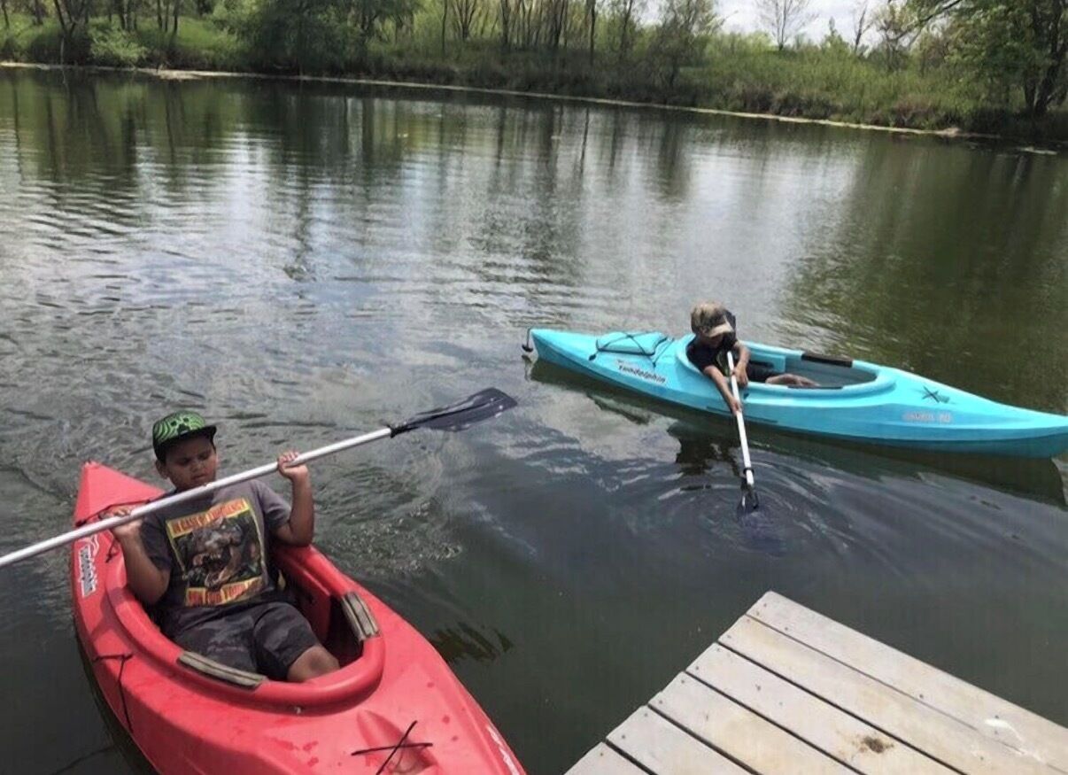 Two kayaks on a calm body of water with a dock in the foreground.