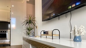 A modern kitchen with a white countertop, a built-in oven, and a TV mounted above the counter. - Casas do Baleeiro - Whaler’s Houses (Machico)