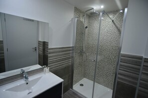 A bathroom with a white sink, a mirror, and a glass-enclosed shower. - Casas do Baleeiro - Whaler’s Houses (Machico)