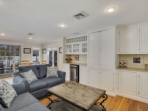 A modern living room with a grey sofa, a coffee table, and white cabinetry.