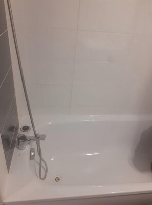 Bathroom features a bathtub and showerhead.