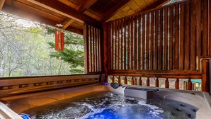 Een hottub met een houten binnenkant en uitzicht op bomen.