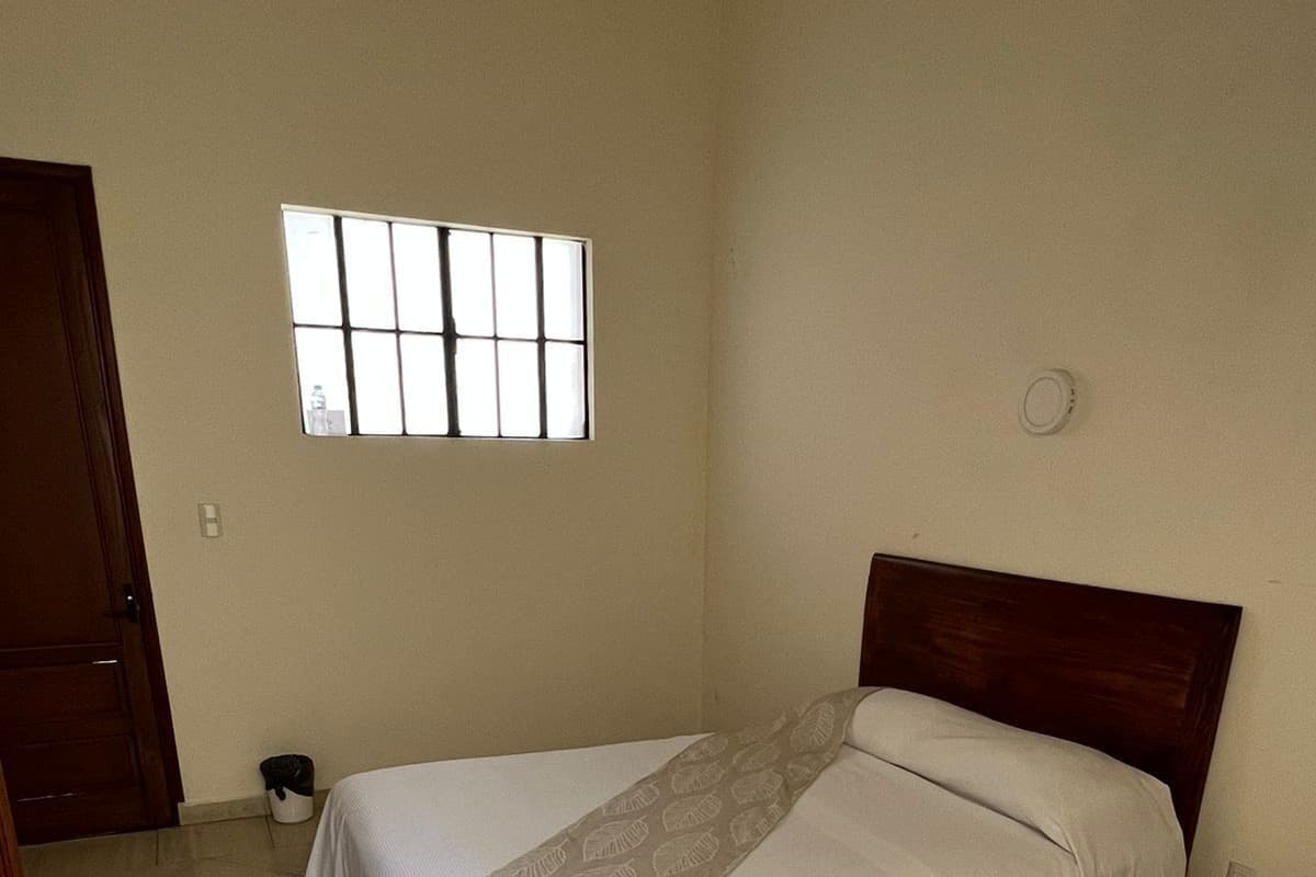 Un dormitorio con cama, ventana y puerta.