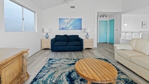 Un salon moderne avec un canapé bleu, une table basse en bois et un canapé beige.