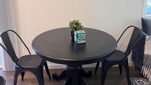 A round table with four black chairs, a small potted plant, and a box on the table. - Cozy 1bd/1bath Apartment Unit in Downtown Vancouver (Vancouver)