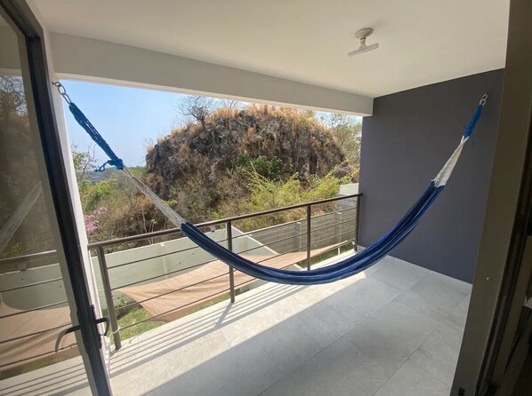 A balcony with a blue hammock.