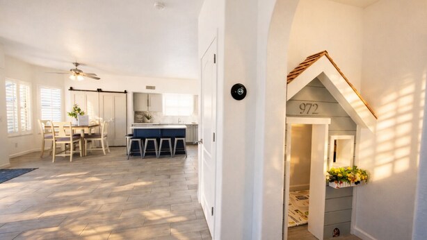 Une cuisine spacieuse avec un coin repas, une petite maisonnette pour jouer et un escalier menant à un niveau supérieur.