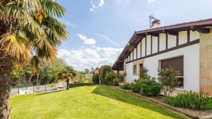 Ein modernes Haus mit gepflegtem Rasen, einer Auffahrt und einer Garage.
