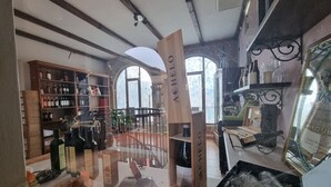 Une cave à vin avec des étagères en bois et une enseigne en bois portant l’inscription « ACHELO ».