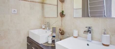 Un baño moderno con dos lavamanos, un espejo y un perchero para toallas.