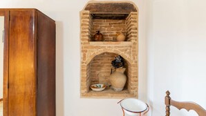 A stone fireplace with a bowl and a vase on the mantel. - Holiday home in Torchiaro with garden (Torchiaro)